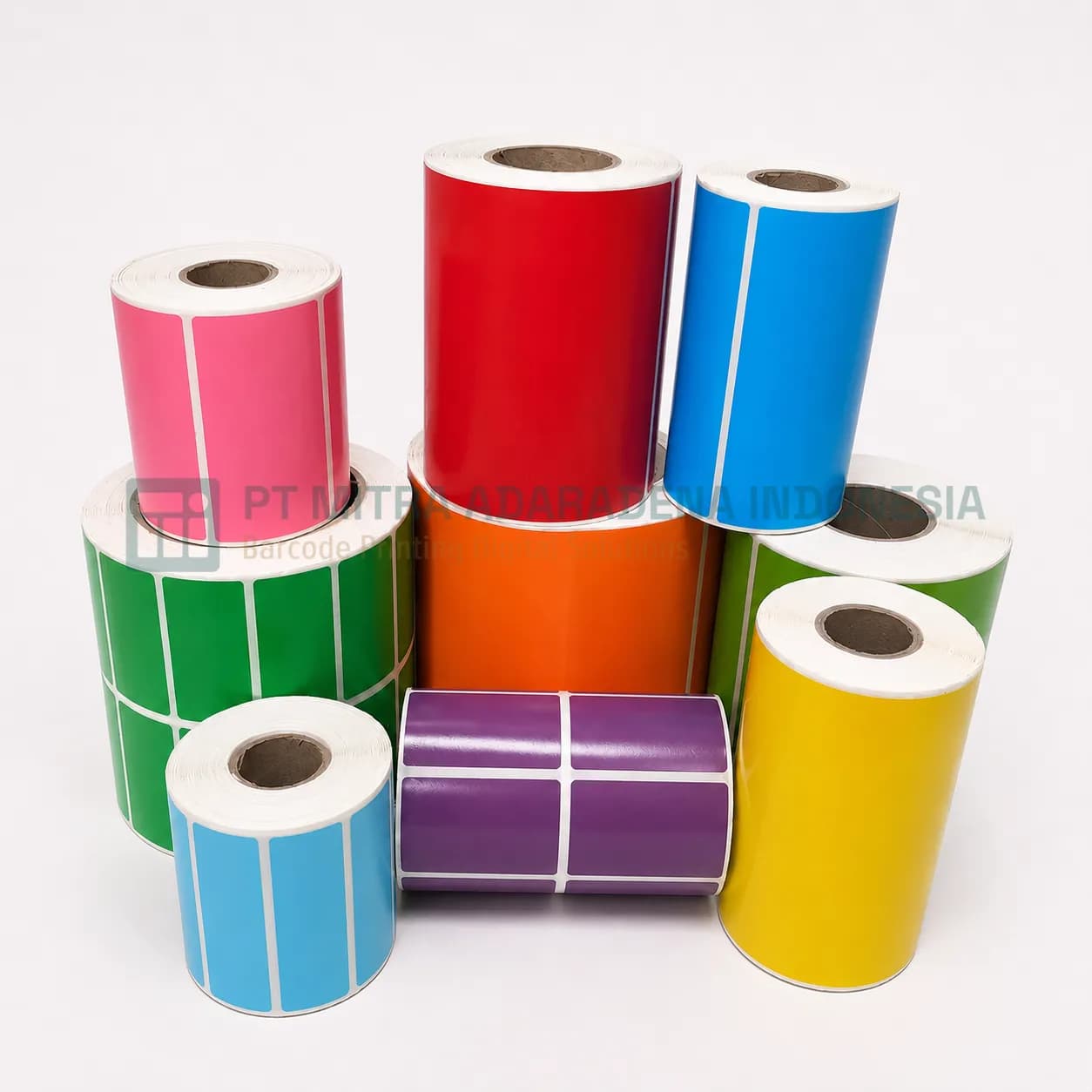 Rolls of plain coloured label stock in pink, red, blue, green, orange, yellow, and purple