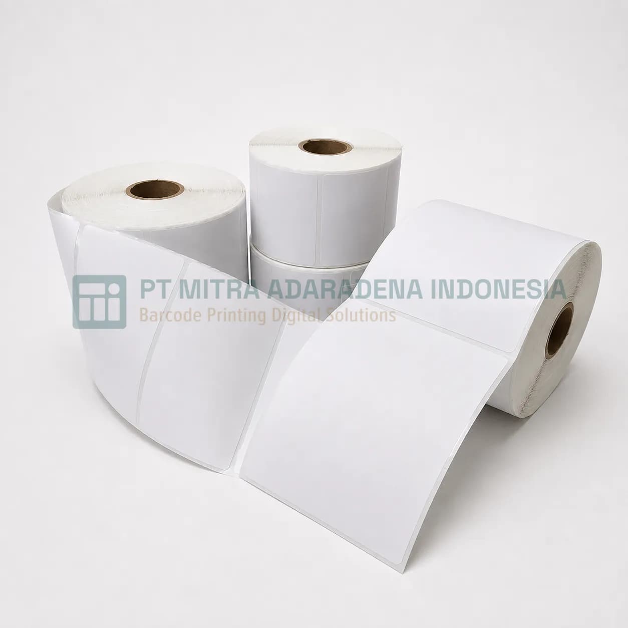 Rolls of uncoated woodfree paper label stock, one unwound to show the die-cut labels
