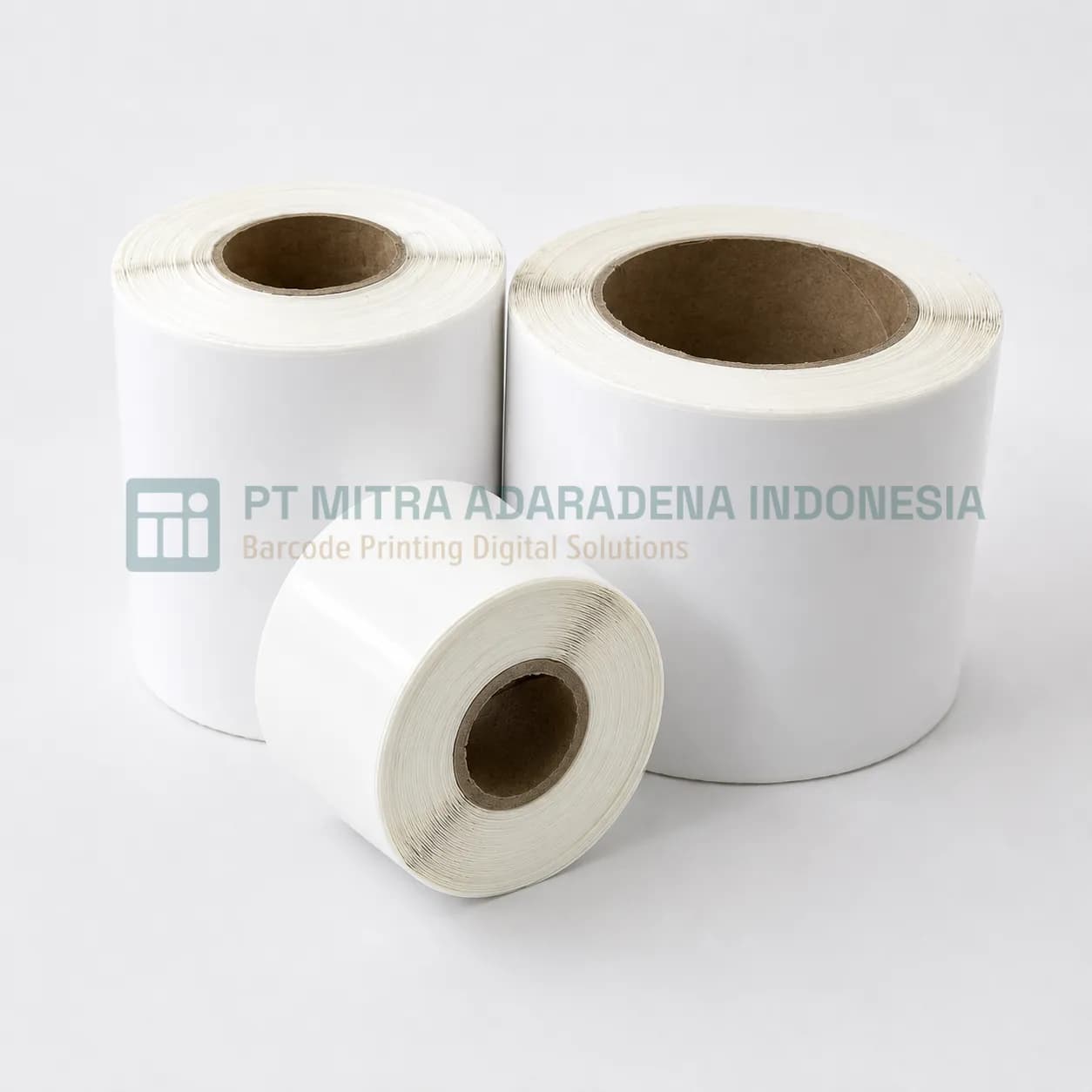 Rolls of Yupo synthetic label stock, one lying on its side in front of two standing rolls